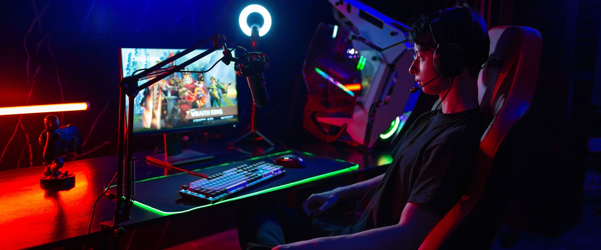 A player at a LORGAR setup in colourful light &mdash; monitor, backlit keyboard and RGB mouse pad