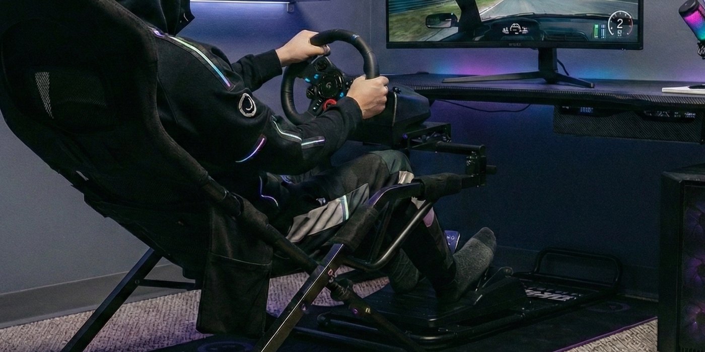 A LORGAR Sim Racing cockpit in use &mdash; wheel, pedals and a monitor running a racing game